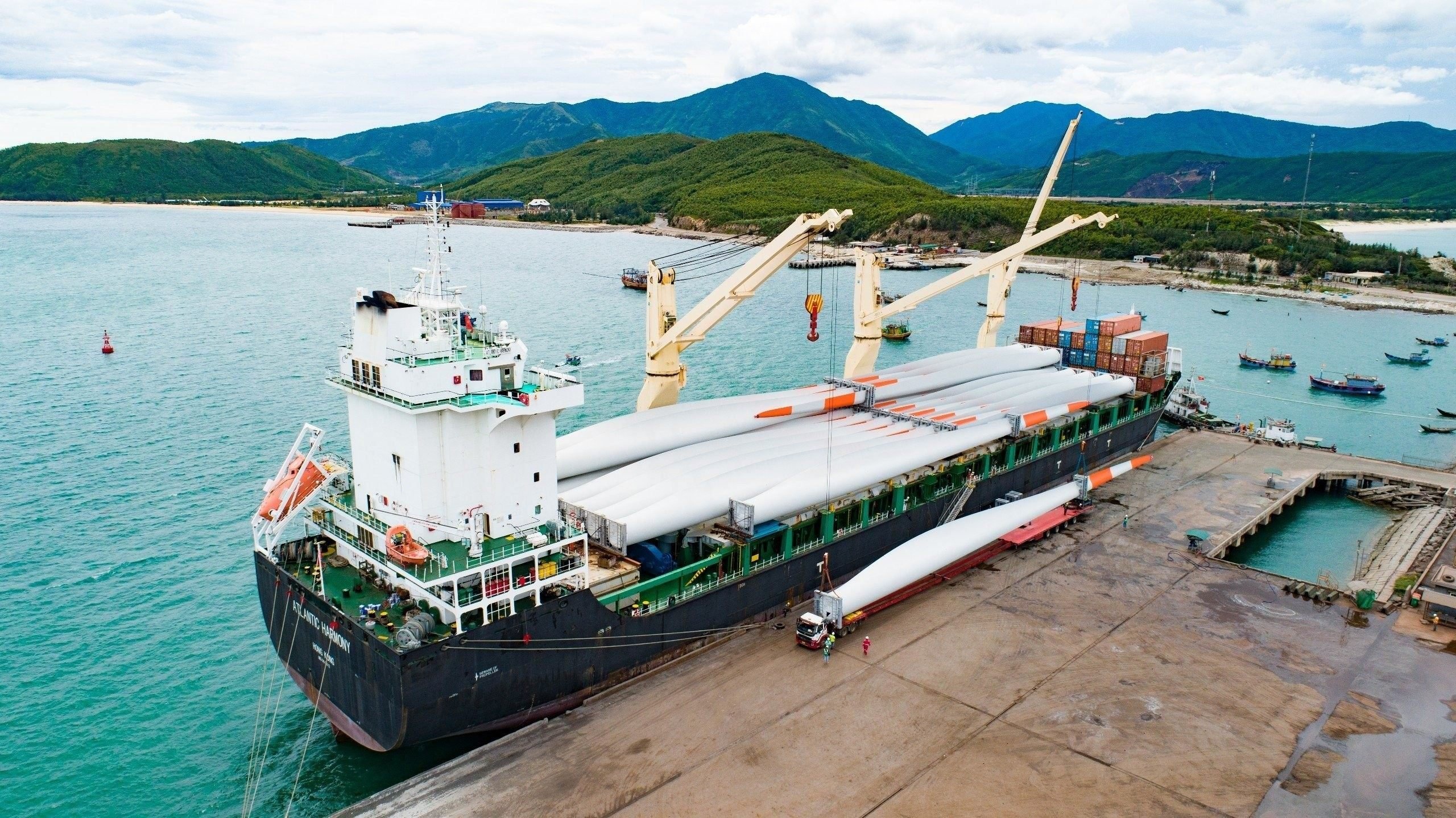 Wind turbine blades being discharged from a vessel at port